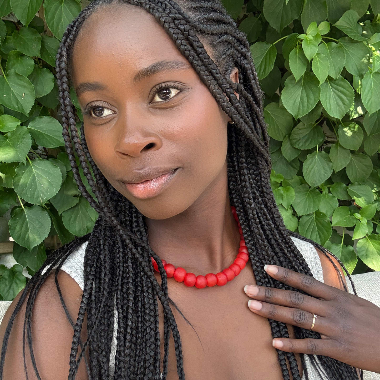 Akoma bold necklace in red from Tòma Lina, shown how to wear around the neck