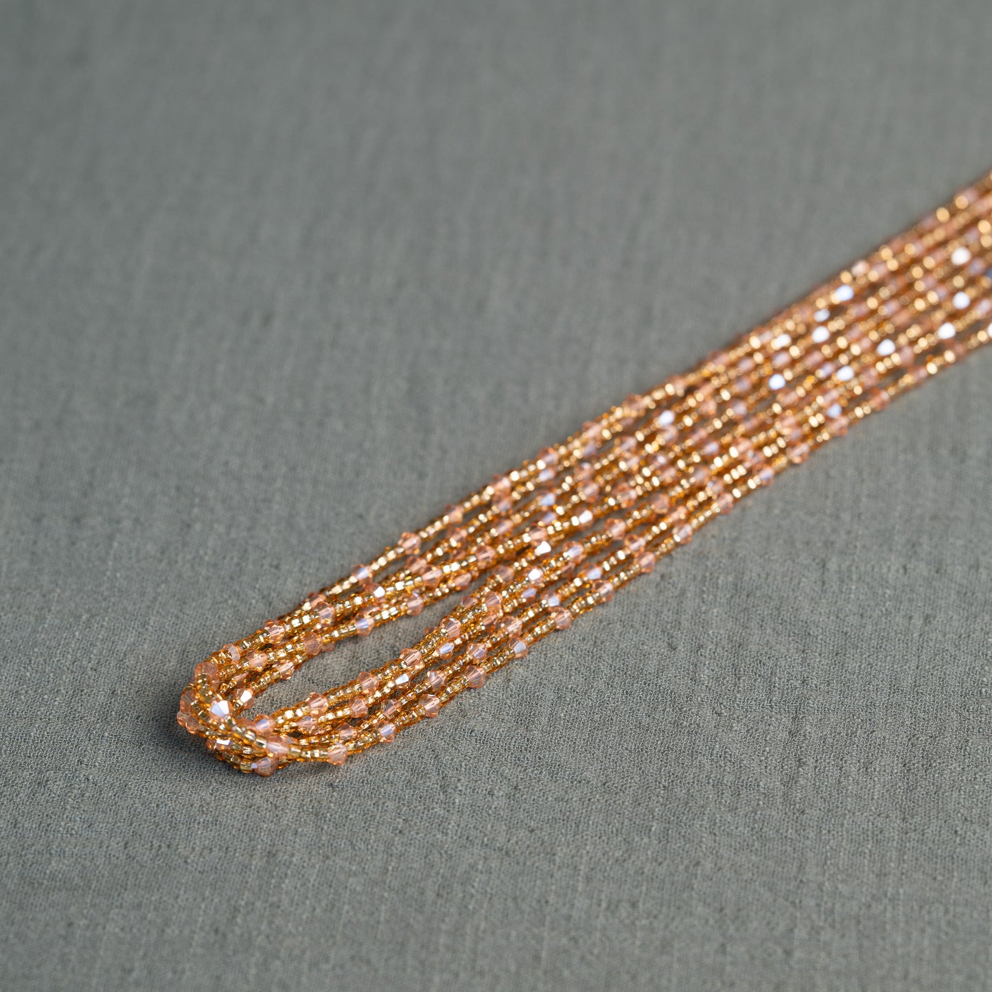 Rose-toned African waist beads with crystal shimmer – tie-on body jewelry symbolizing self-growth and feminine blooming.