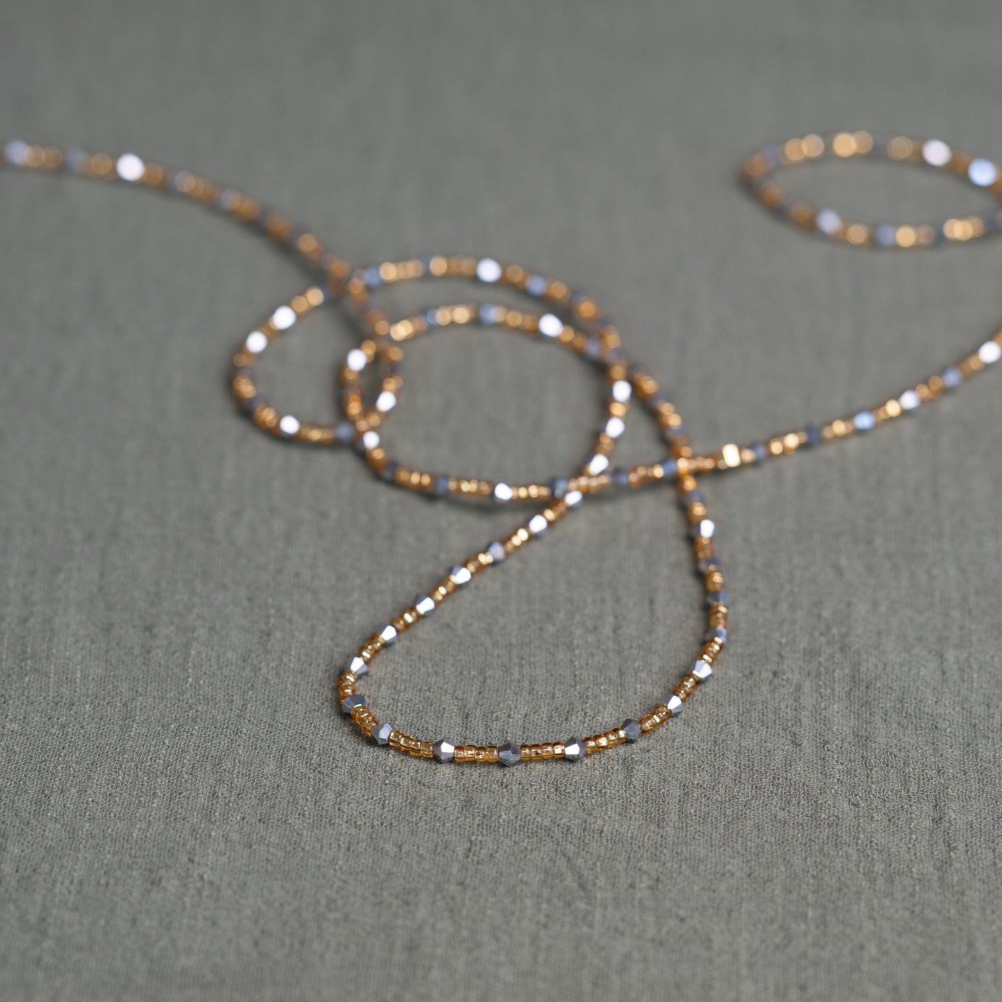 Handmade African waist beads in silver-grey and gold tones – tie-on body jewelry from Ghana for spiritual strength and balance.