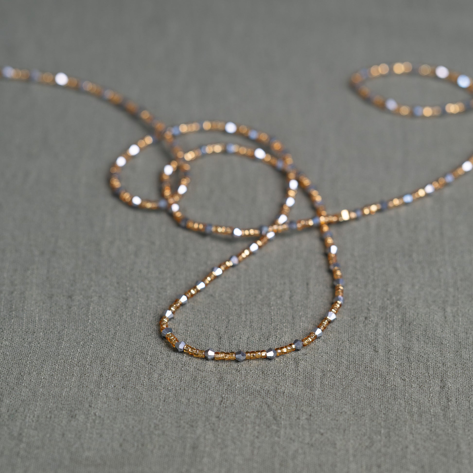 Handmade African waist beads in silver-grey and gold tones – tie-on body jewelry from Ghana for spiritual strength and balance.