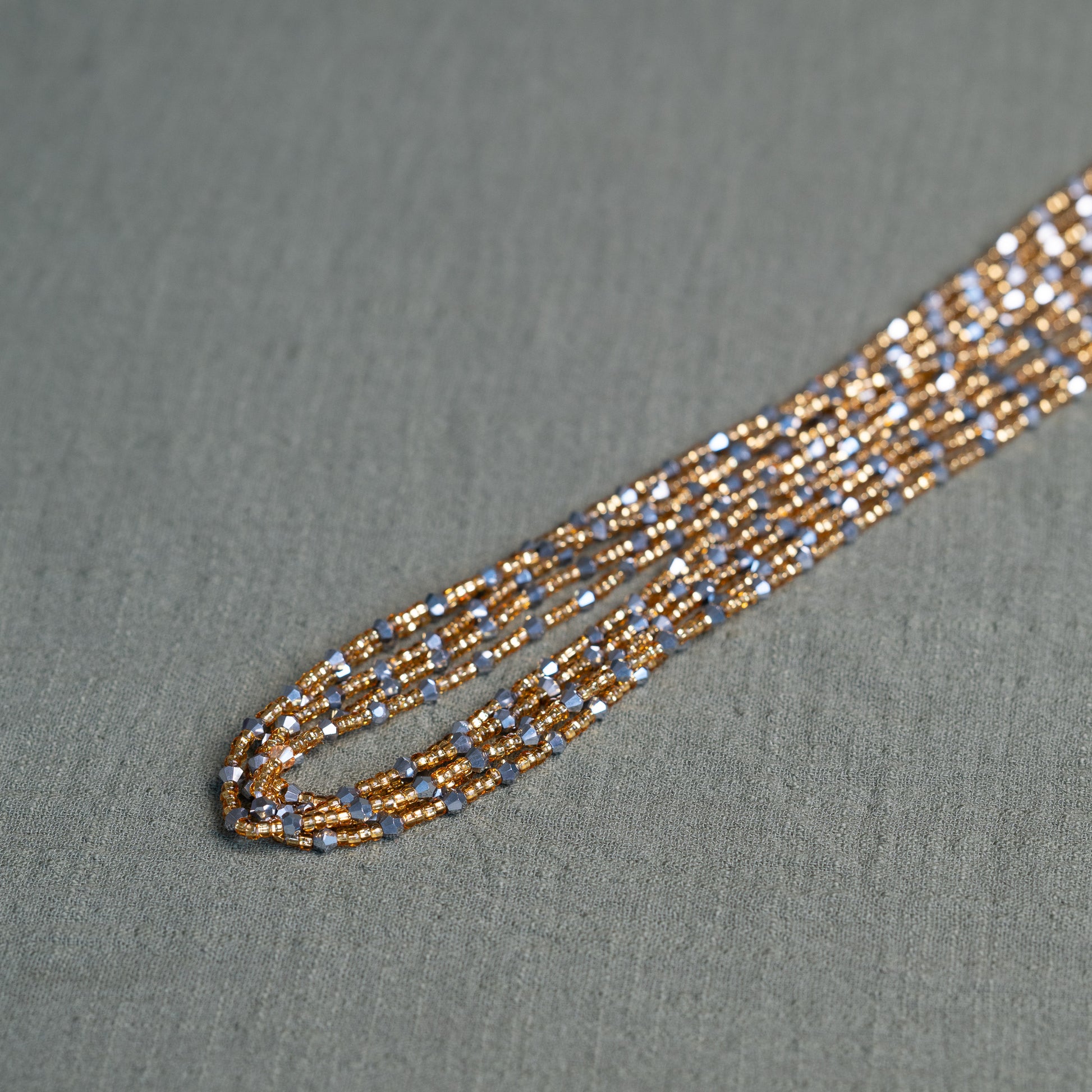 Handmade African waist beads in silver-grey and gold tones – tie-on body jewelry from Ghana for spiritual strength and balance.