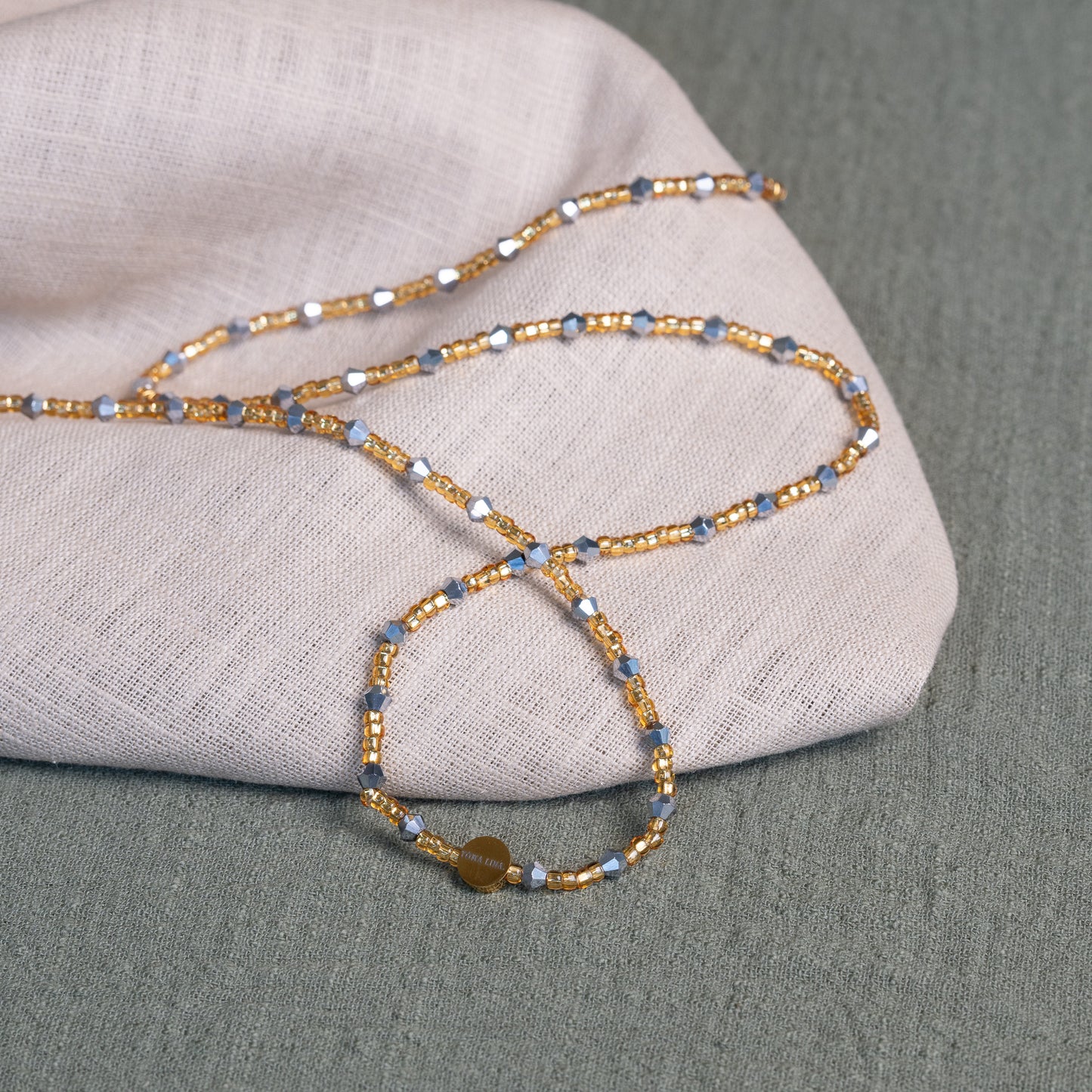Handmade African waist beads in silver-grey and gold tones – tie-on body jewelry from Ghana for spiritual strength and balance.