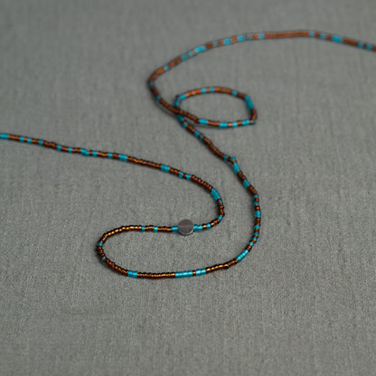 Earth-toned Ghanaian waist beads in turquoise and bronze – traditional African body jewelry representing rooted femininity.