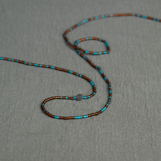 Earth-toned Ghanaian waist beads in turquoise and bronze – traditional African body jewelry representing rooted femininity.