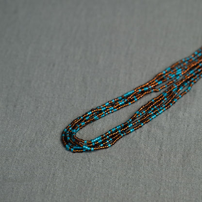 Earth-toned Ghanaian waist beads in turquoise and bronze – traditional African body jewelry representing rooted femininity.