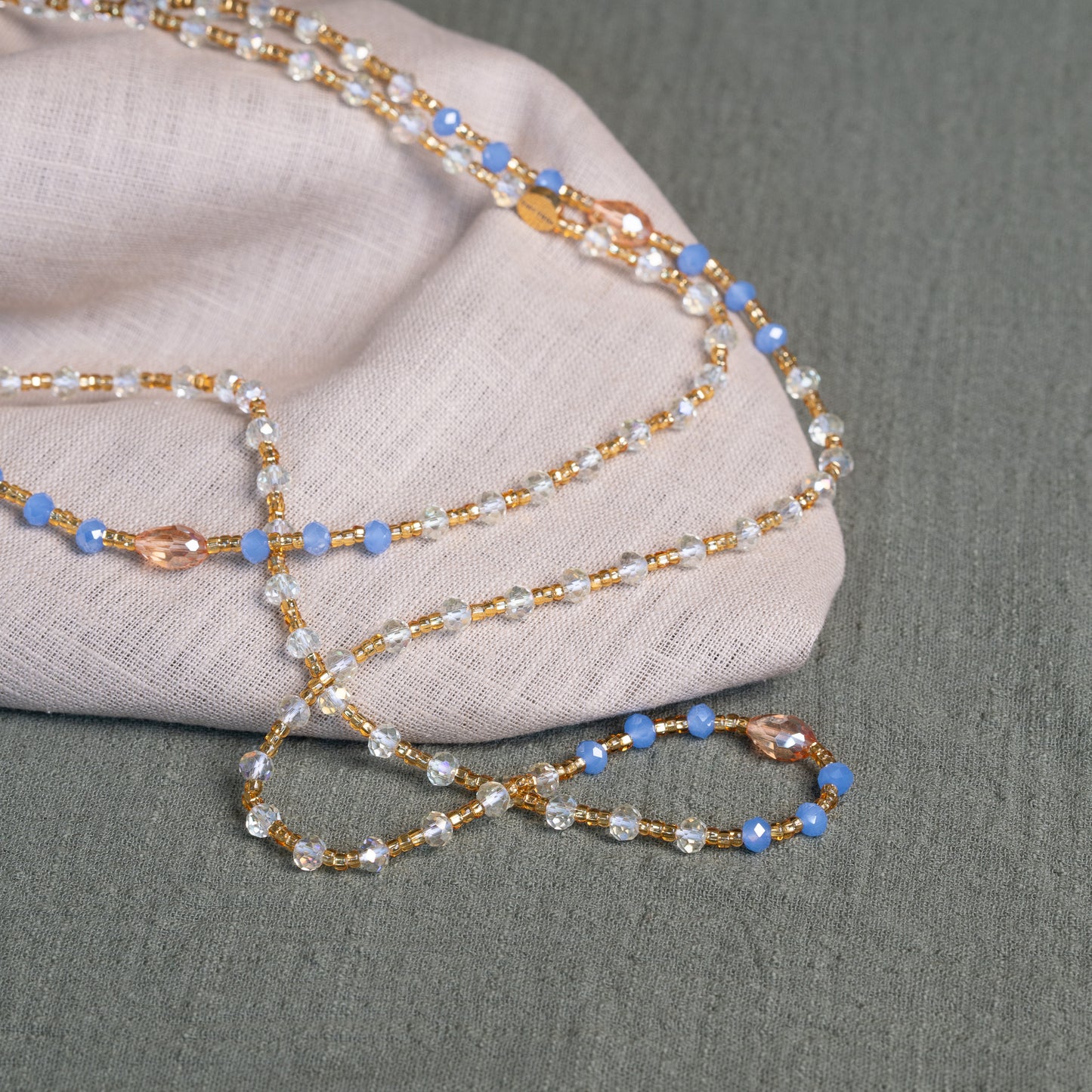 Soft blue and golden handmade waist beads – calming African body jewelry from Ghana designed for emotional healing.