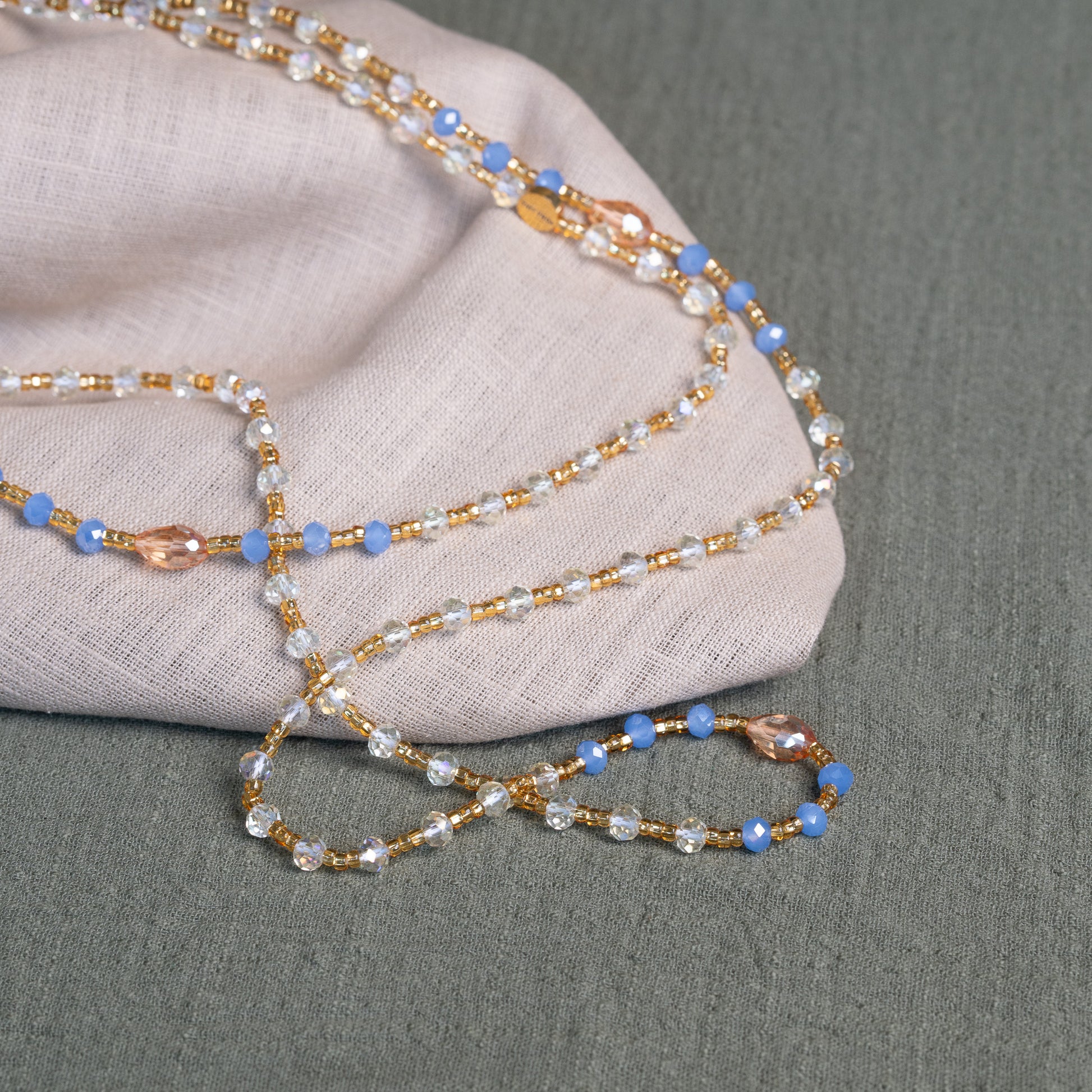 Soft blue and golden handmade waist beads – calming African body jewelry from Ghana designed for emotional healing.