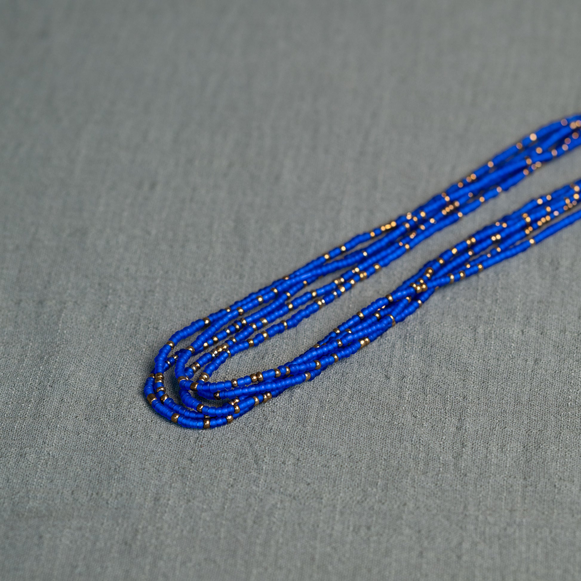 Tòma Lina Electric Blue waist bead, handmade with vibrant Ghanaian beads in a bold blue shade symbolizing confidence, energy and inner strength.