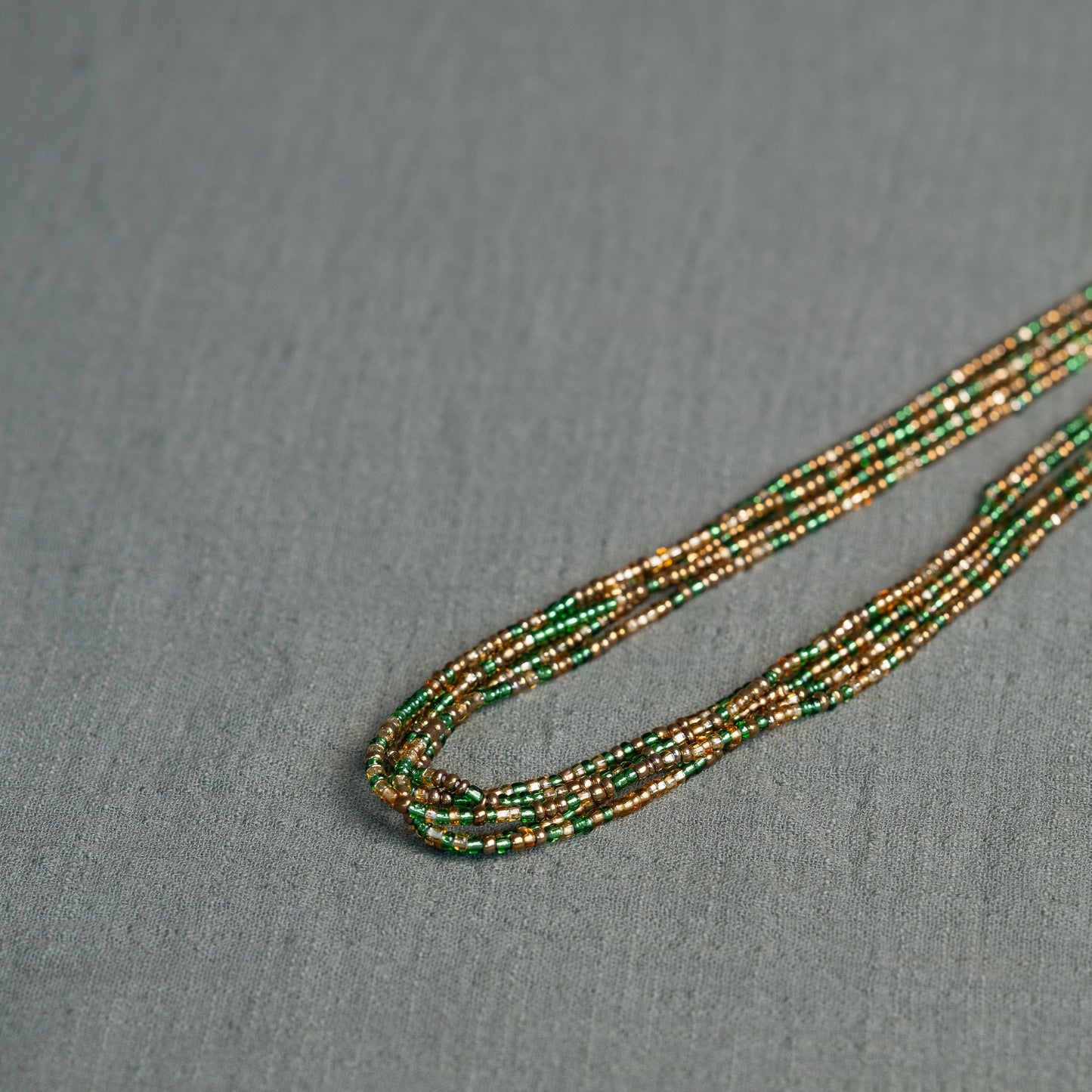 Tòma Lina Emerald Green waist bead, handmade with authentic Ghanaian beads in a deep green shade symbolizing growth and renewal.