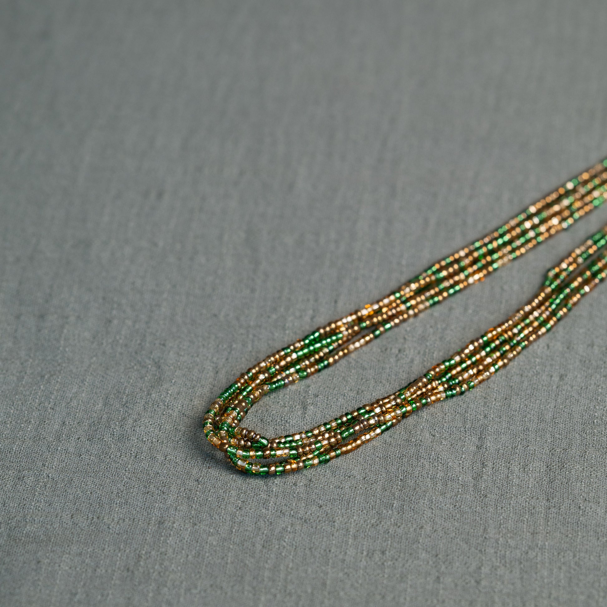 Tòma Lina Emerald Green waist bead, handmade with authentic Ghanaian beads in a deep green shade symbolizing growth and renewal.