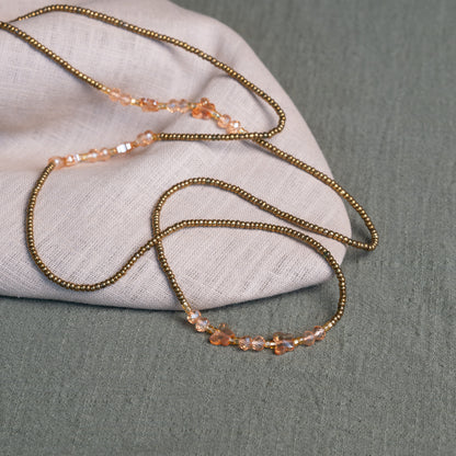 Waist beads with butterfly detail in pink and gold – spiritual African body jewelry handcrafted in Ghana for transformation.