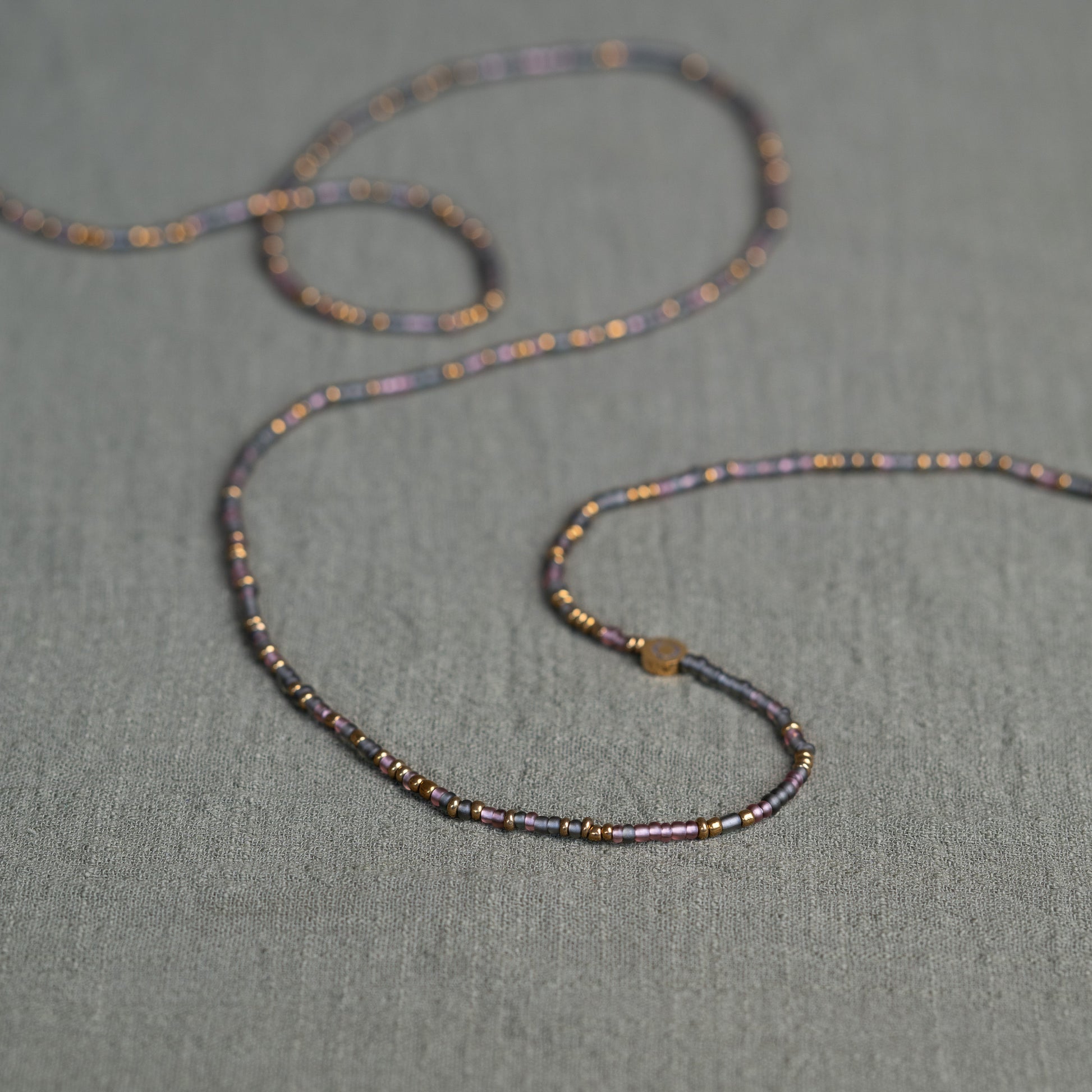 Tòma Lina Purple Rain waist bead, handmade with authentic Ghanaian beads in a rich purple tone symbolizing intuition, empowerment and spiritual depth.