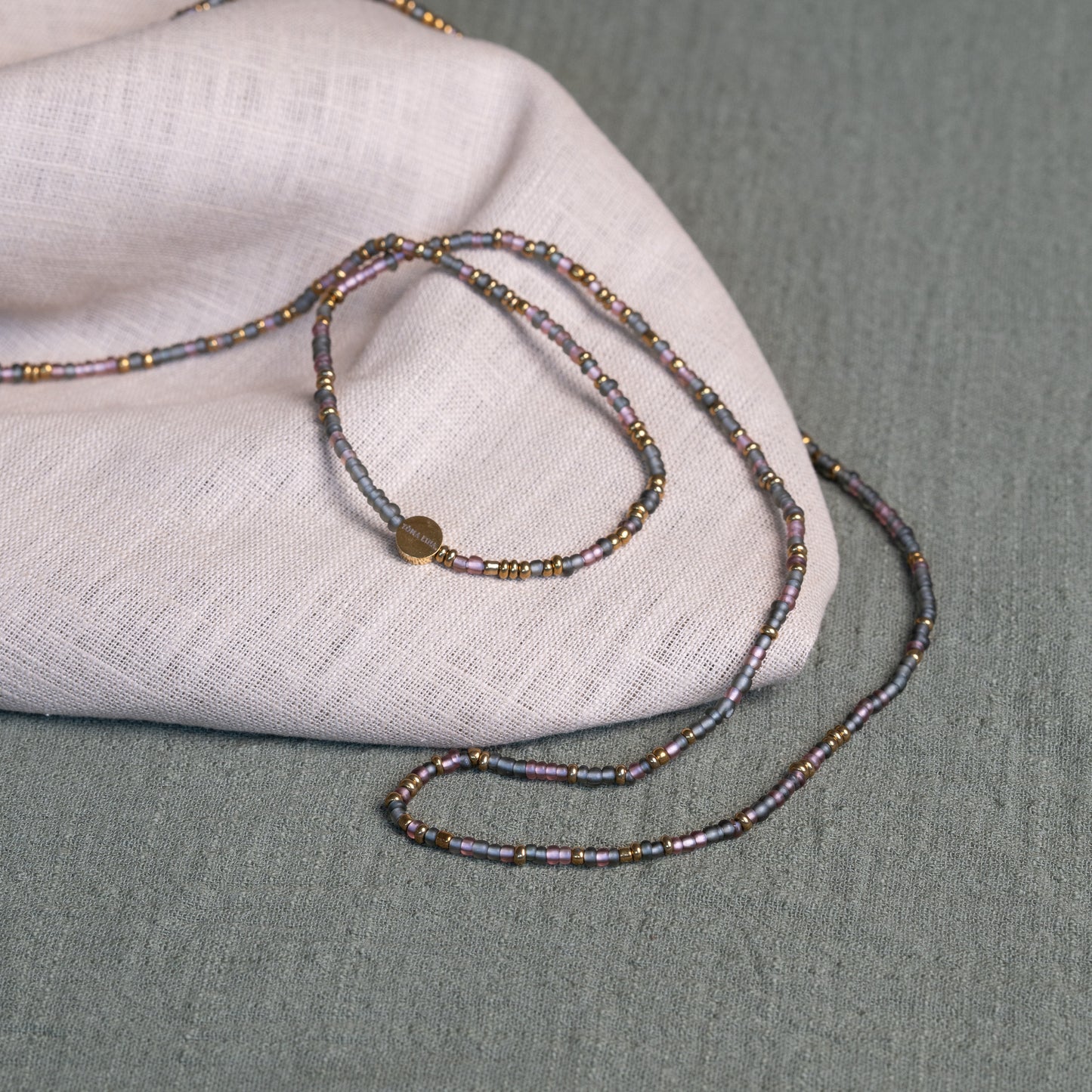 Tòma Lina Purple Rain waist bead, handmade with authentic Ghanaian beads in a rich purple tone symbolizing intuition, empowerment and spiritual depth.