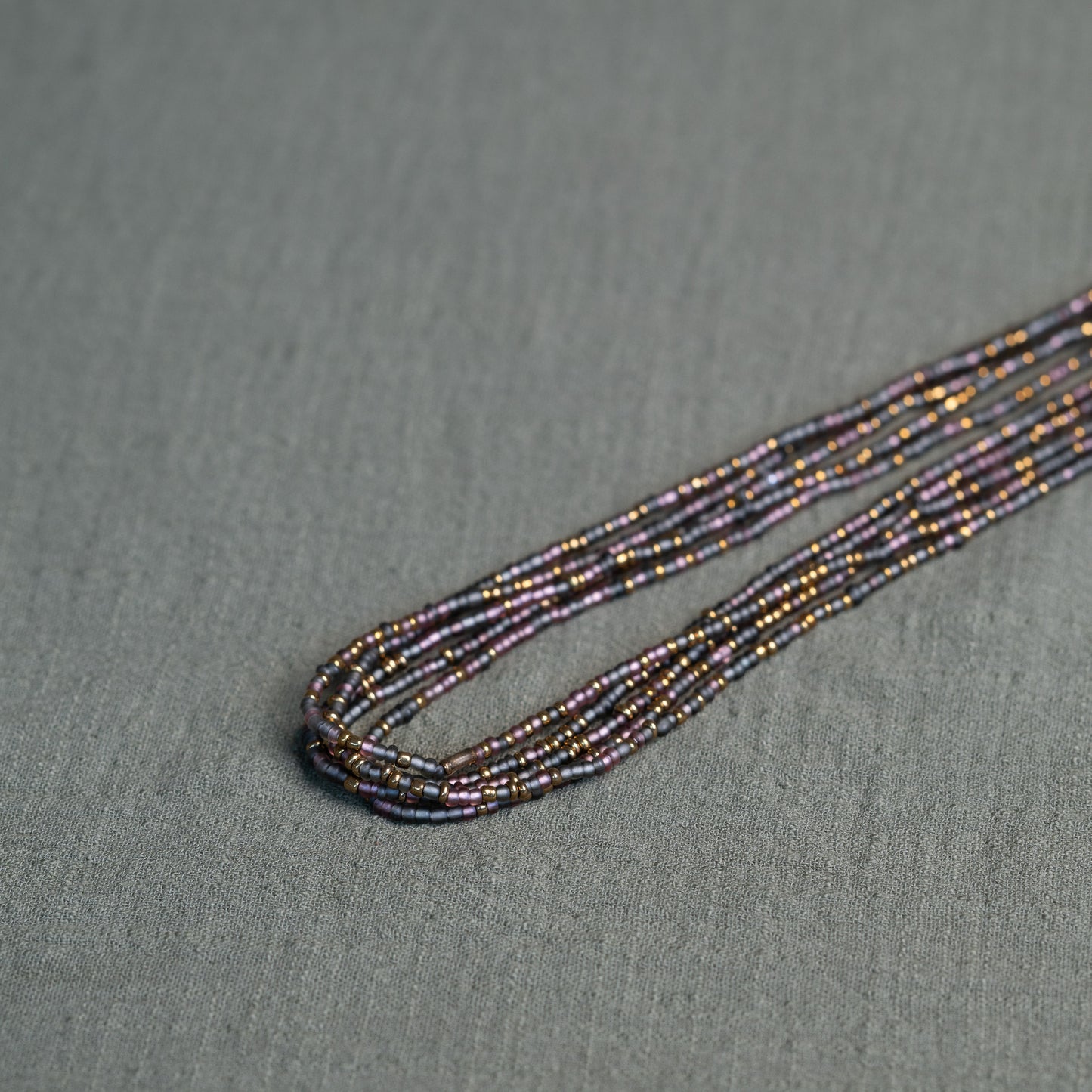 Tòma Lina Purple Rain waist bead, handmade with authentic Ghanaian beads in a rich purple tone symbolizing intuition, empowerment and spiritual depth.