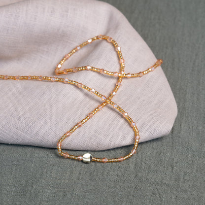 Rose-toned African waist beads with crystal shimmer – tie-on body jewelry symbolizing self-growth and feminine blooming.